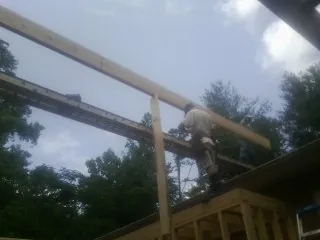 Carpenter setting a ridge beam over a new addition frame — Ice Dam Removal by Roofing Brothers in Bolingbrook