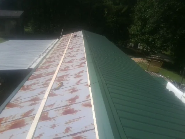 Old rusted panels beside newly installed green metal roofing — Wind Damage Roof Repair by Roofing Brothers in Bolingbrook