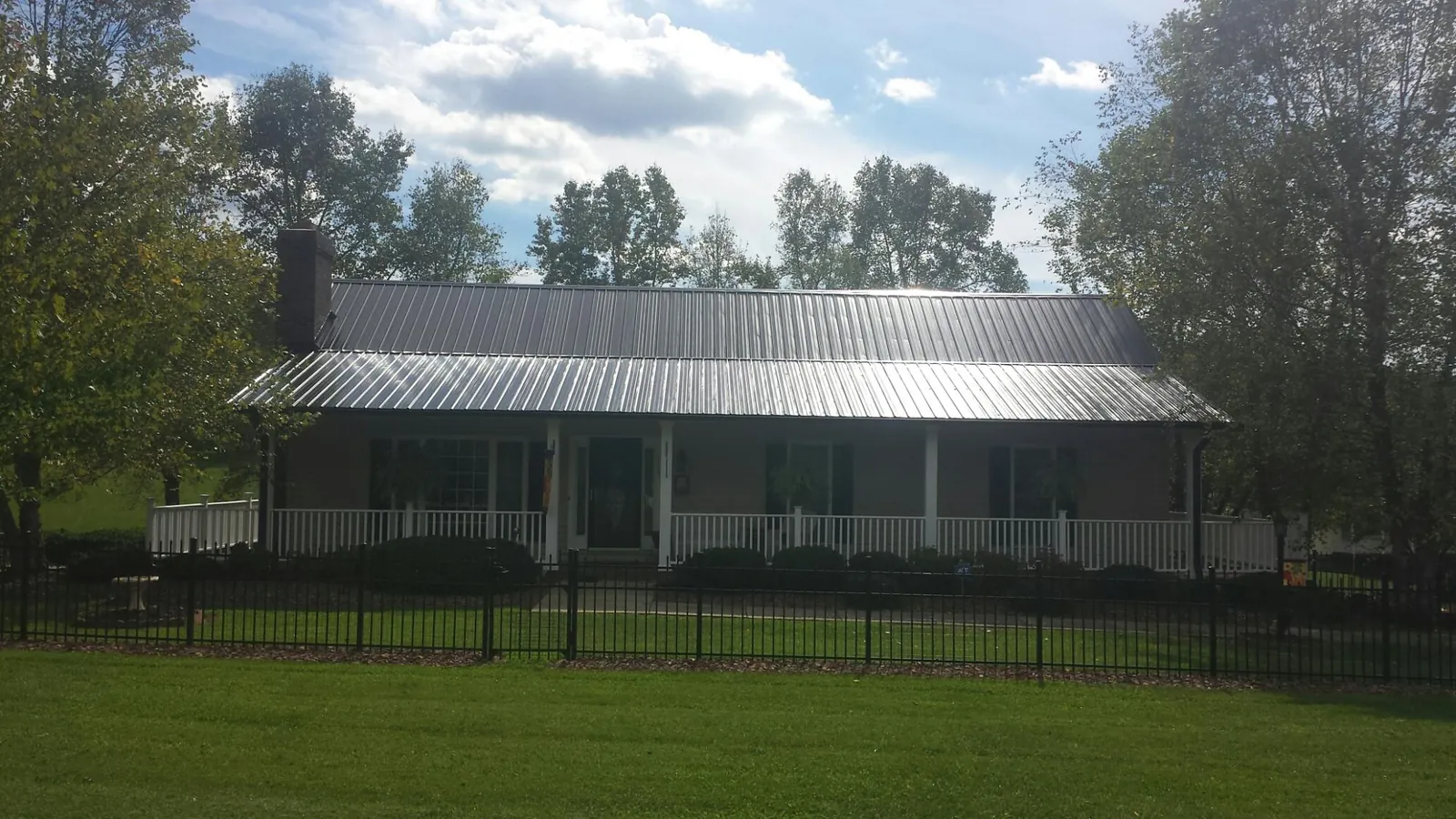 Gray metal roof on a brick ranch with a full width front porch — Gutter Guard Installation work by our crew in Bolingbrook