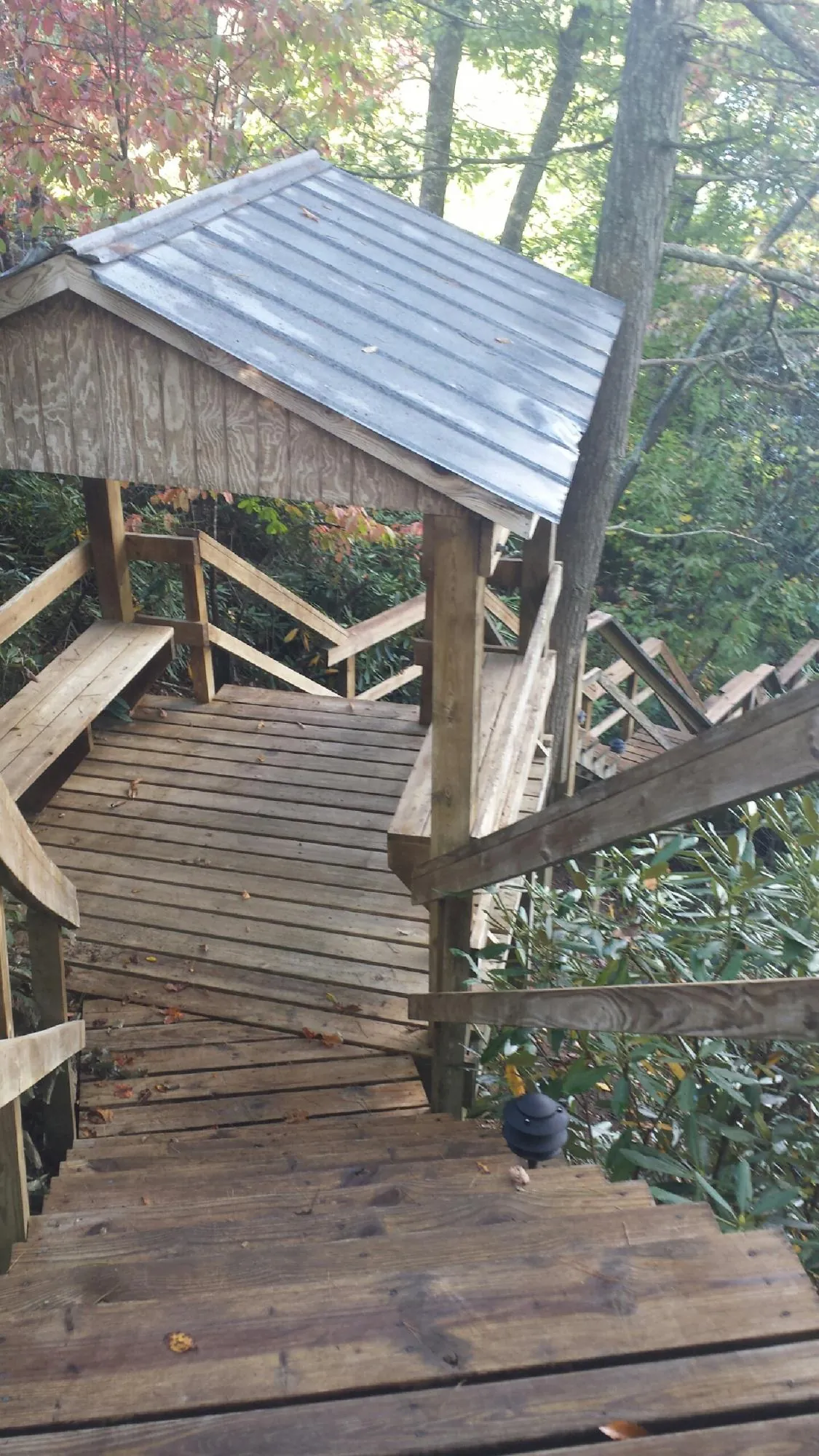 Metal roofed shelter over wooden steps on a wooded walkway — Skylight Repair & Installation work by our crew in Bolingbrook