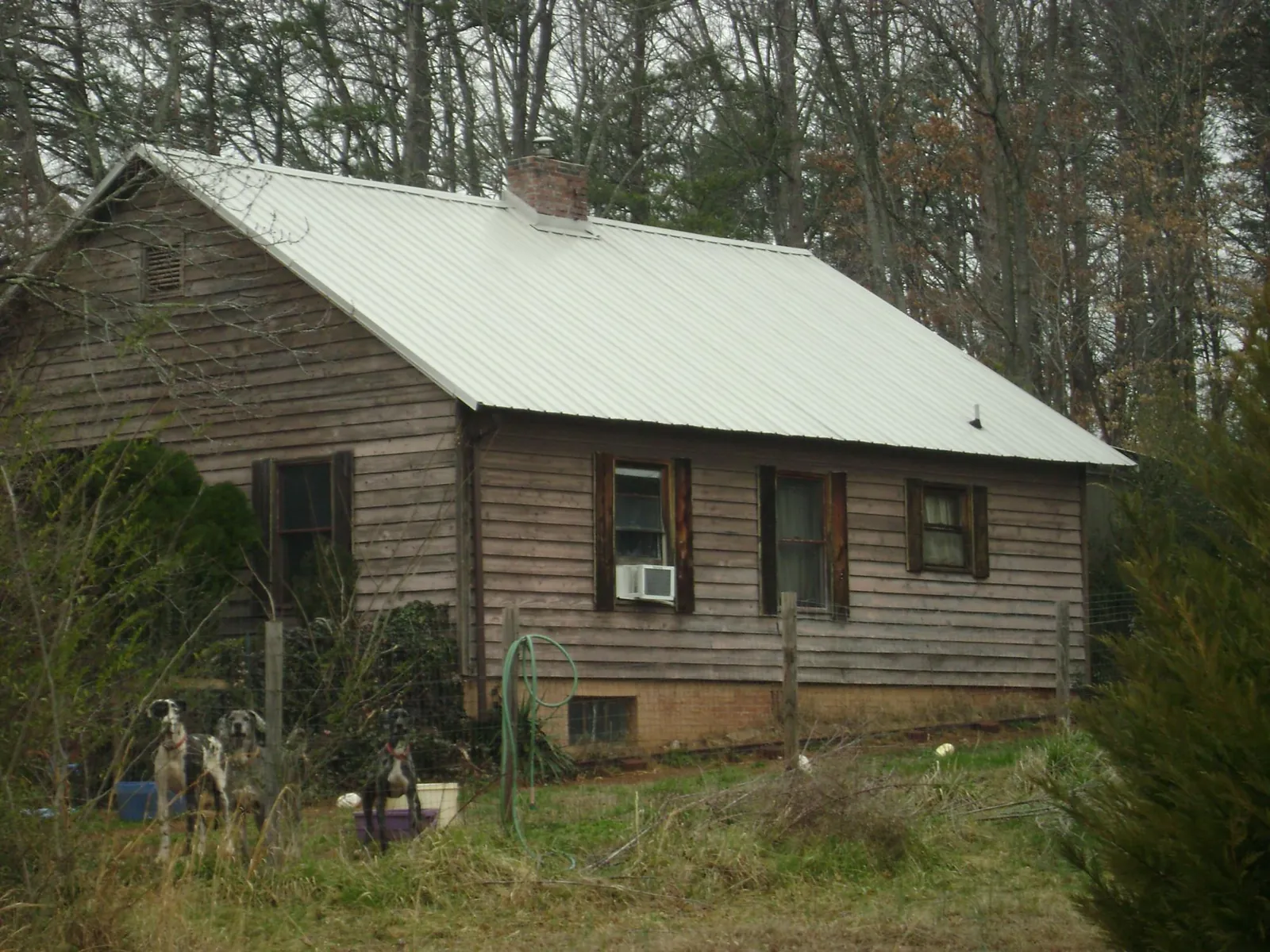 White metal roof on an old wood sided farmhouse, from a Metal Roof Installation job in Bolingbrook